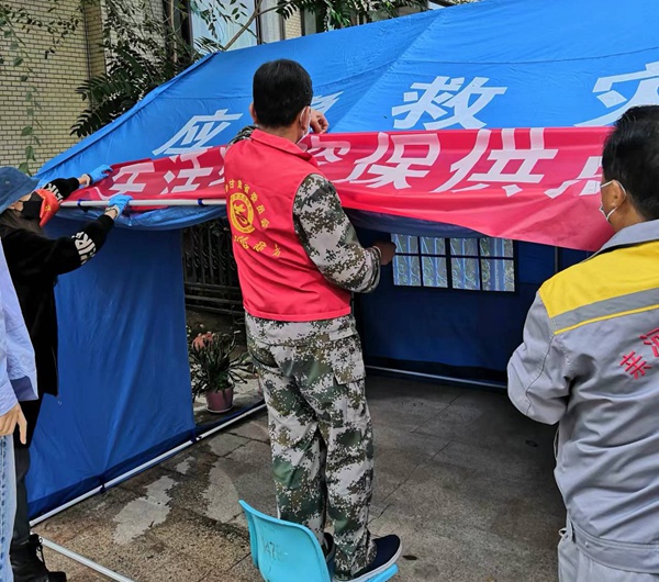 志愿者搭建保供點帳篷。冉麗蘭攝