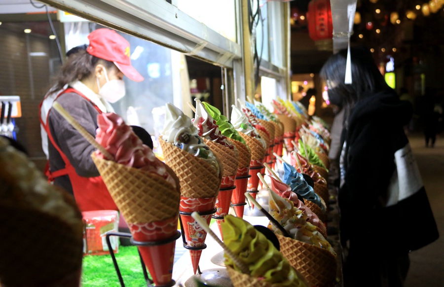 游客在甘肅敦煌夜市選購特色小吃。張曉亮攝