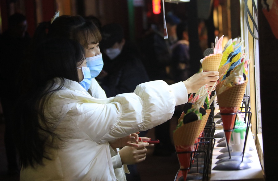 游客在甘肅敦煌夜市選購特色小吃。張曉亮攝