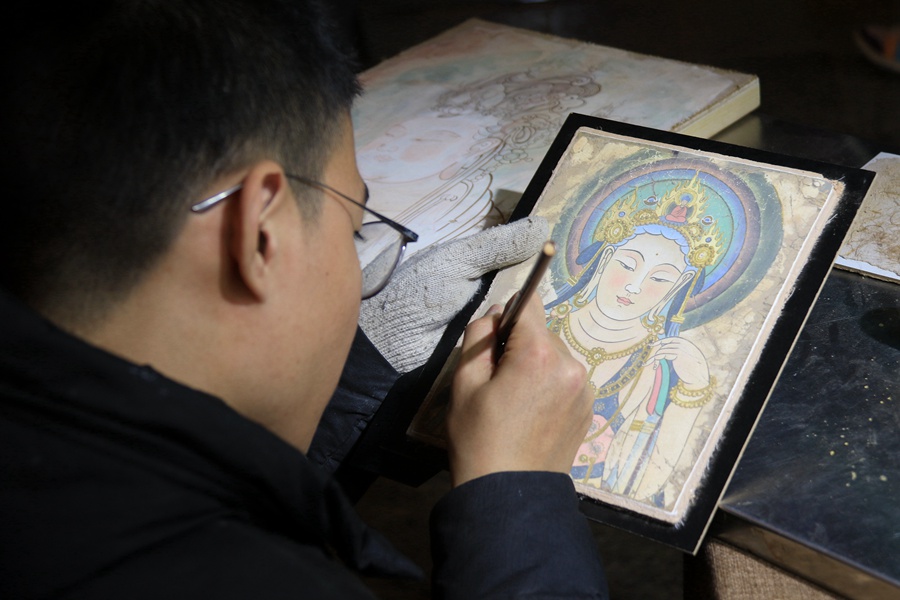 泥板畫藝人在敦煌夜市繪制泥板畫作品。張曉亮攝