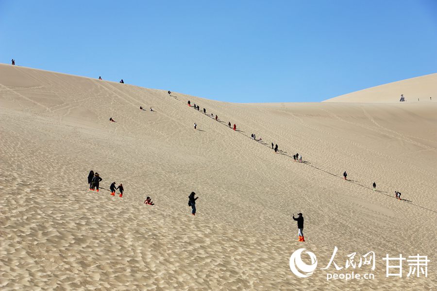 游客們在鳴沙山月牙泉景區內游玩。人民網記者 王文嘉攝