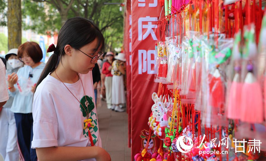 在慶陽民俗文化普品展銷區，色彩艷麗、做工精湛的香包吸引了眾多市民游客駐足。人民網記者 邵蘭攝