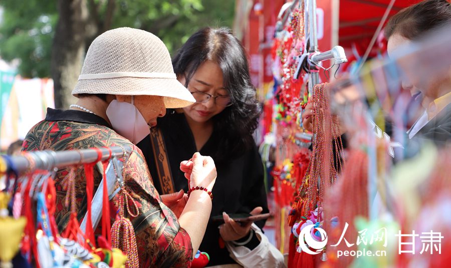 在慶陽民俗文化普品展銷區，色彩艷麗、做工精湛的香包吸引了眾多市民游客駐足。人民網記者 邵蘭攝