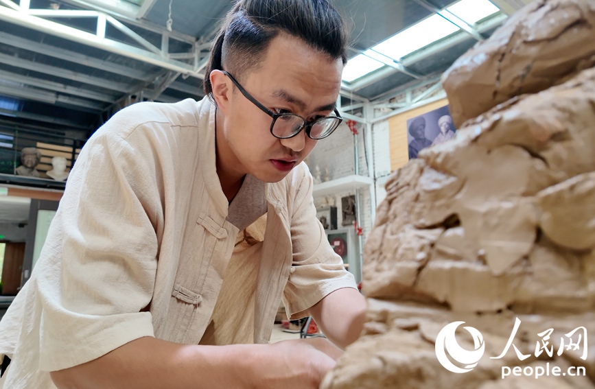 尤路平正在專心制作泥塑。人民網 李根攝