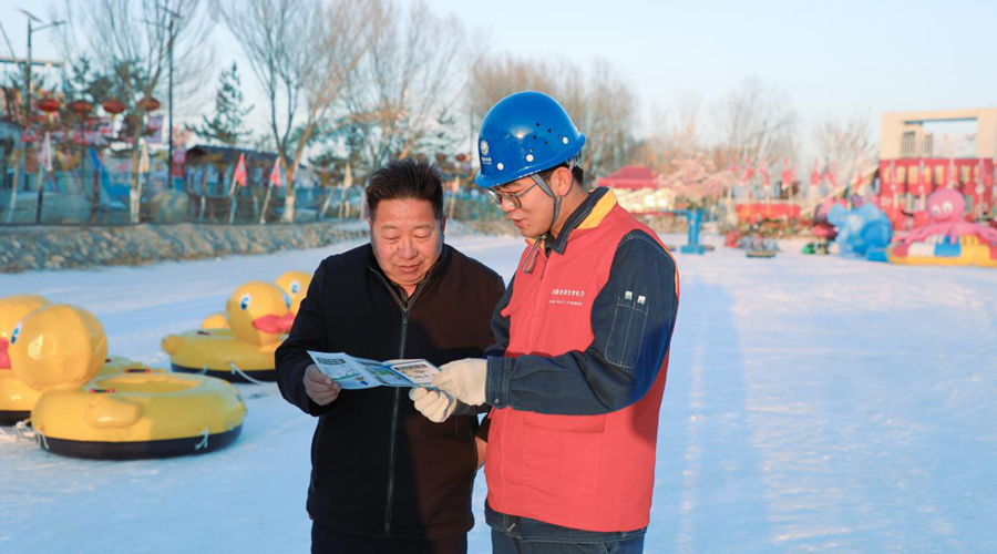 國網酒泉供電公司員工針對造雪機等設備向冰雪樂園工作人員講解安全用電知識。裴勇峰攝