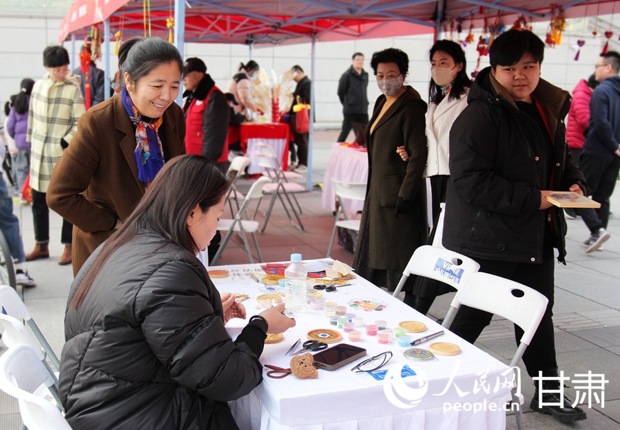 在古韻非遺傳承區，市民體驗掐絲琺瑯制作。人民網記者 米媛攝