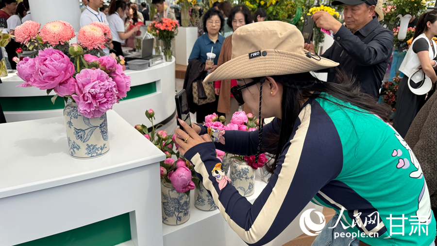 游客在臨夏市牡丹產業園花卉藝術中心內賞花游玩。人民網記者 焦隆攝