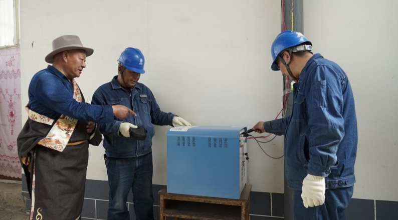 供電員工在牧民家中檢查用電情況。李旋攝