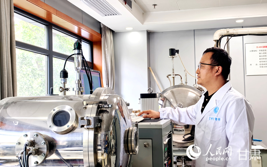 中國科學院蘭州化學物理研究所實驗室內，研究人員正在查看相關監測數據。人民網記者 高翔攝