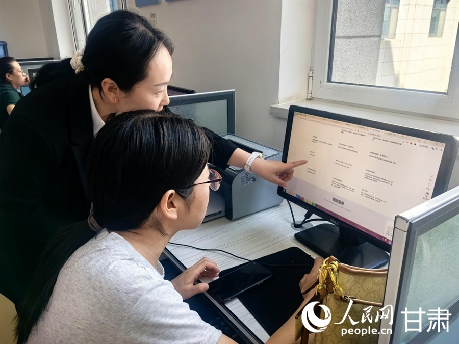 蘭州新區政務服務大廳便民自助服務區工作人員協助企業負責人填寫申報材料。人民網記者 周婉婷攝