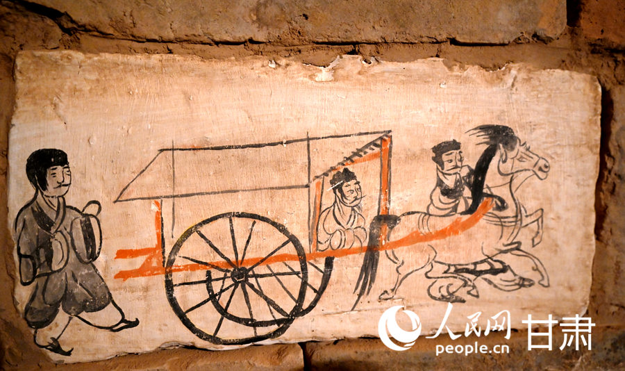 駱駝城苦水1號墓復原墓葬—車馬出行圖壁畫磚（復制品）。