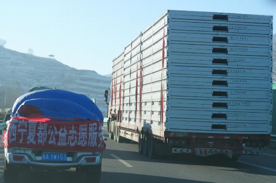 12月24日，行駛在前往青海省海東市民和縣的高速公路上的支援物資車。人民網記者 甘海瓊攝