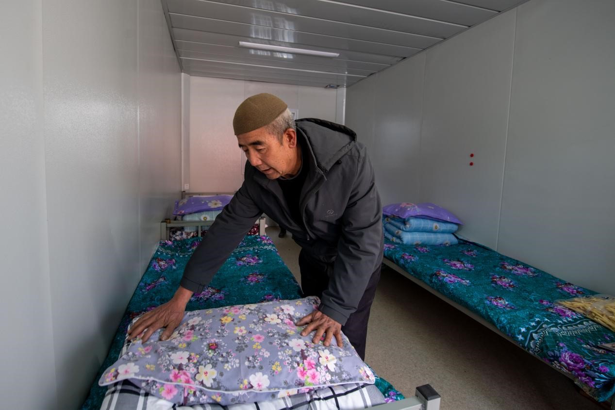 12月22日，在積石山縣劉集鄉陶家村，已經入住臨時安置箱式房的地震受災群眾正在整理被褥。人民網記者 翁奇羽攝